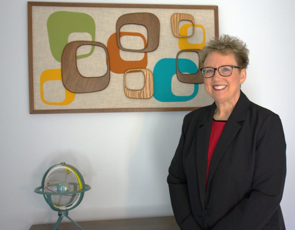 A woman standing in front of a painting.